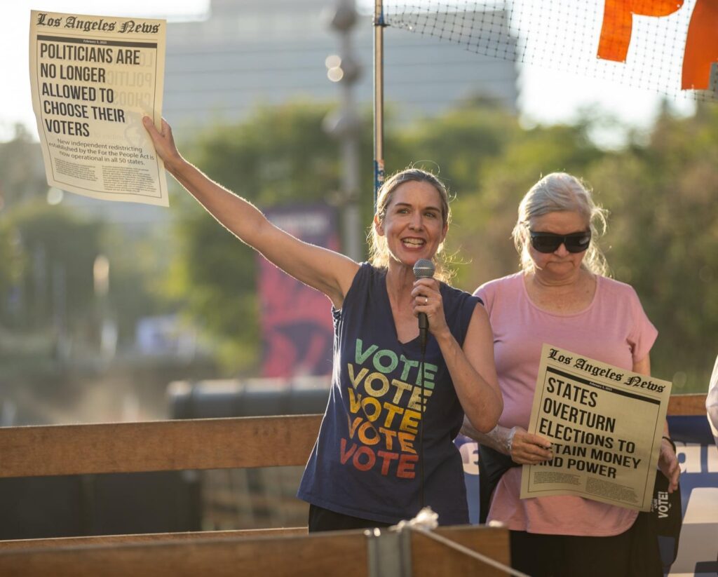 Woman holds a Los Angeles newspaper encouraging women to vote.